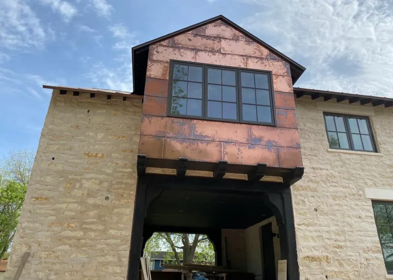 Copper metal panel facade on a stone building for Skylight Installation in Rogers